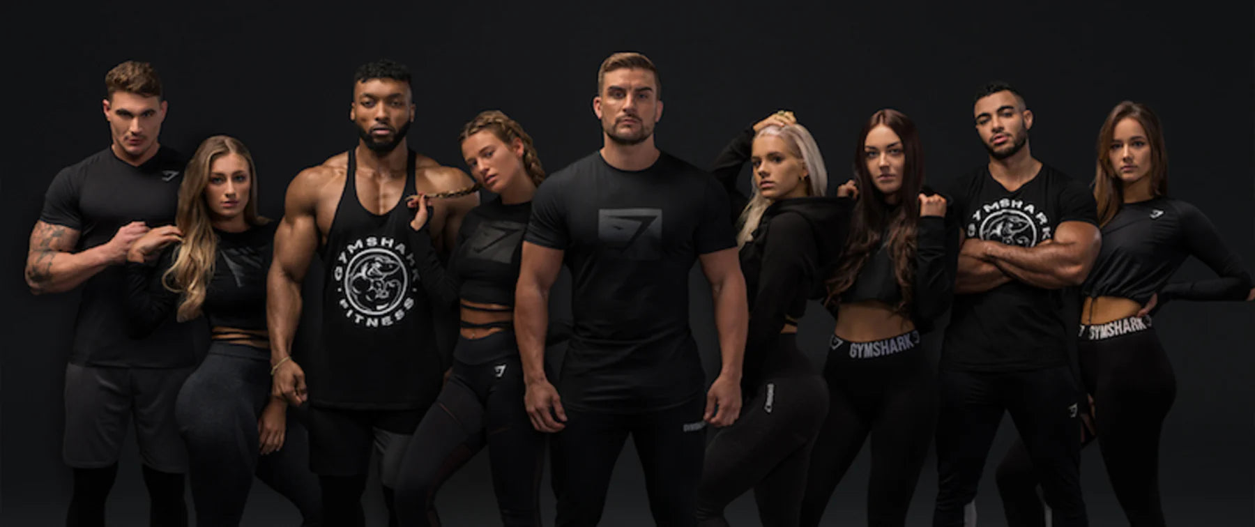 Group of people wearing black athletic wear with logos on a dark background